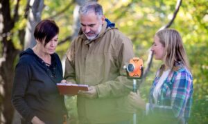 Surveying team reviewing parcel data on site with property survey equipment