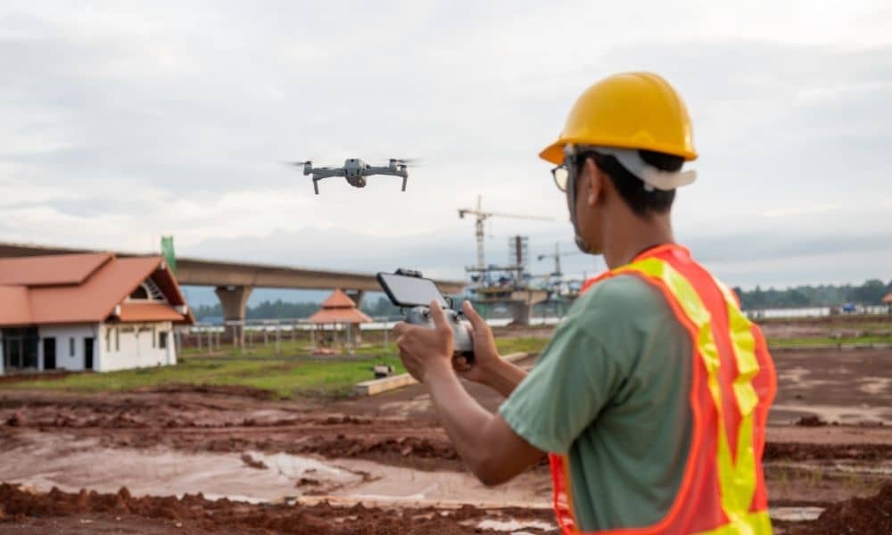 Surveyor flying aerial survey drones over a construction site to capture mapping data