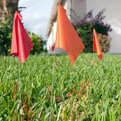 Boundary stakes and survey markers for fence layout - ALTA SURVEY Indiana Survey stakes and flags marking boundary lines during a property survey for fence placement