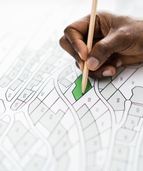 Reviewing land survey map and boundary plan - ALTA SURVEY Indiana A professional highlighting a property boundary on a detailed land survey map during a property line survey review