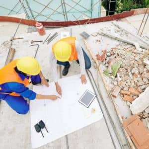 Blueprint review team site planning - ALTA SURVEY Indiana Construction professionals reviewing layout plans as part of a construction survey to ensure accurate building placement