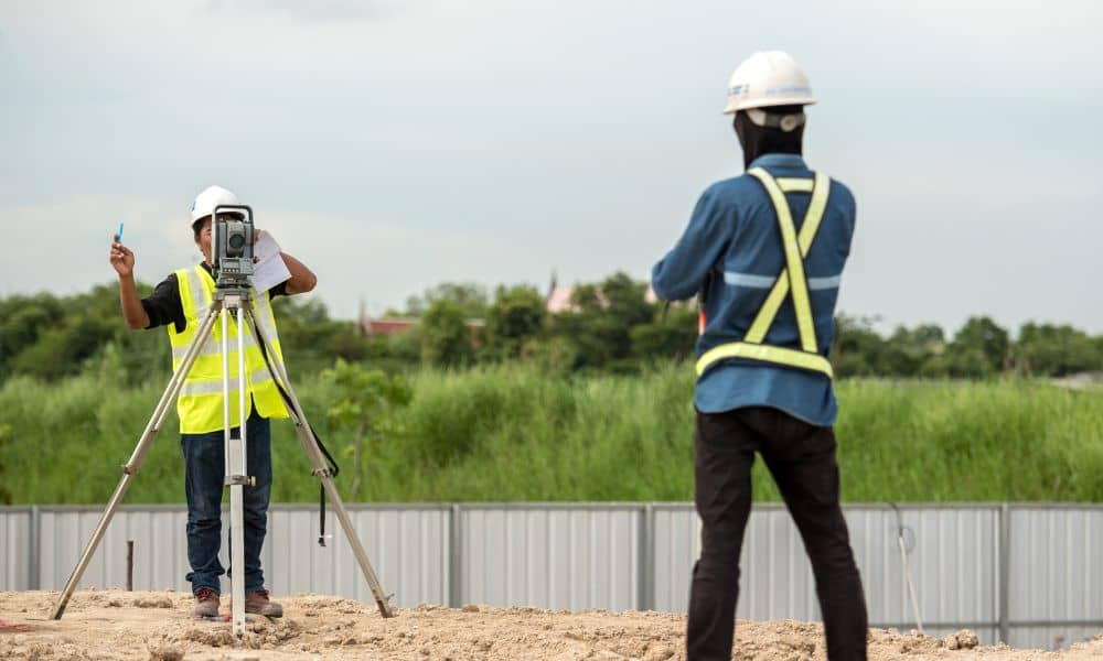 Licensed land surveyor performing a property survey for fence placement to mark accurate boundary lines