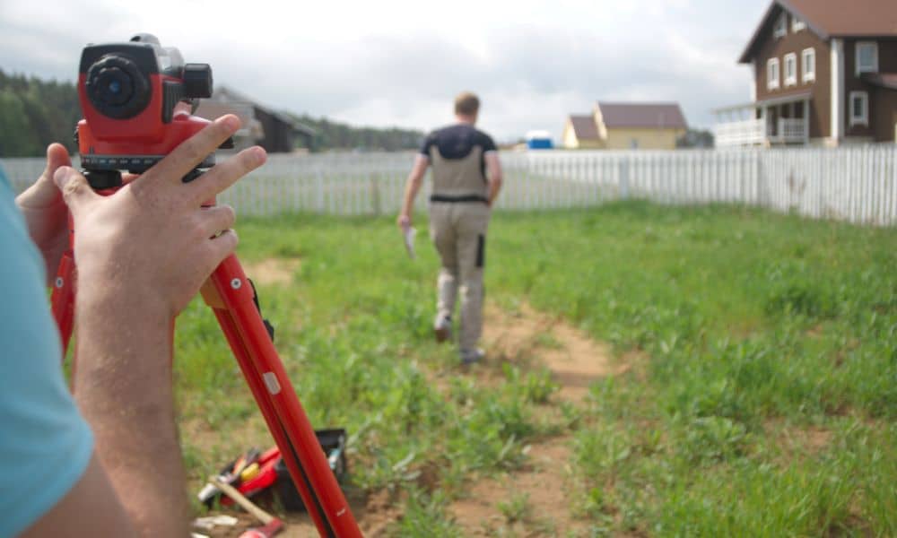 Residential property boundary survey backyard - ALTA SURVEY Indiana Surveyor marking property corners in a suburban backyard to determine boundary survey price for a residential lot